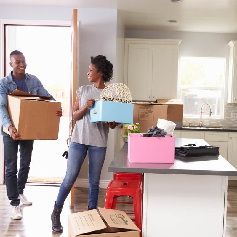 couple carrying boxes into apartment