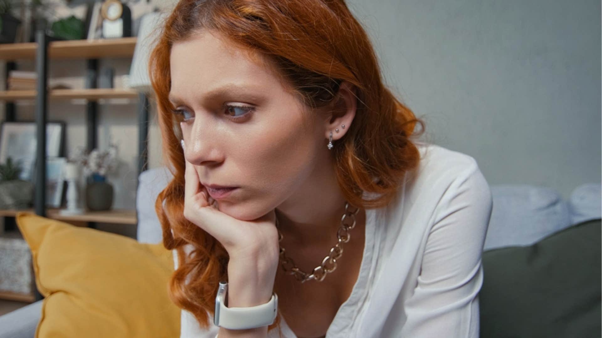 Woman looking upset on her couch. 