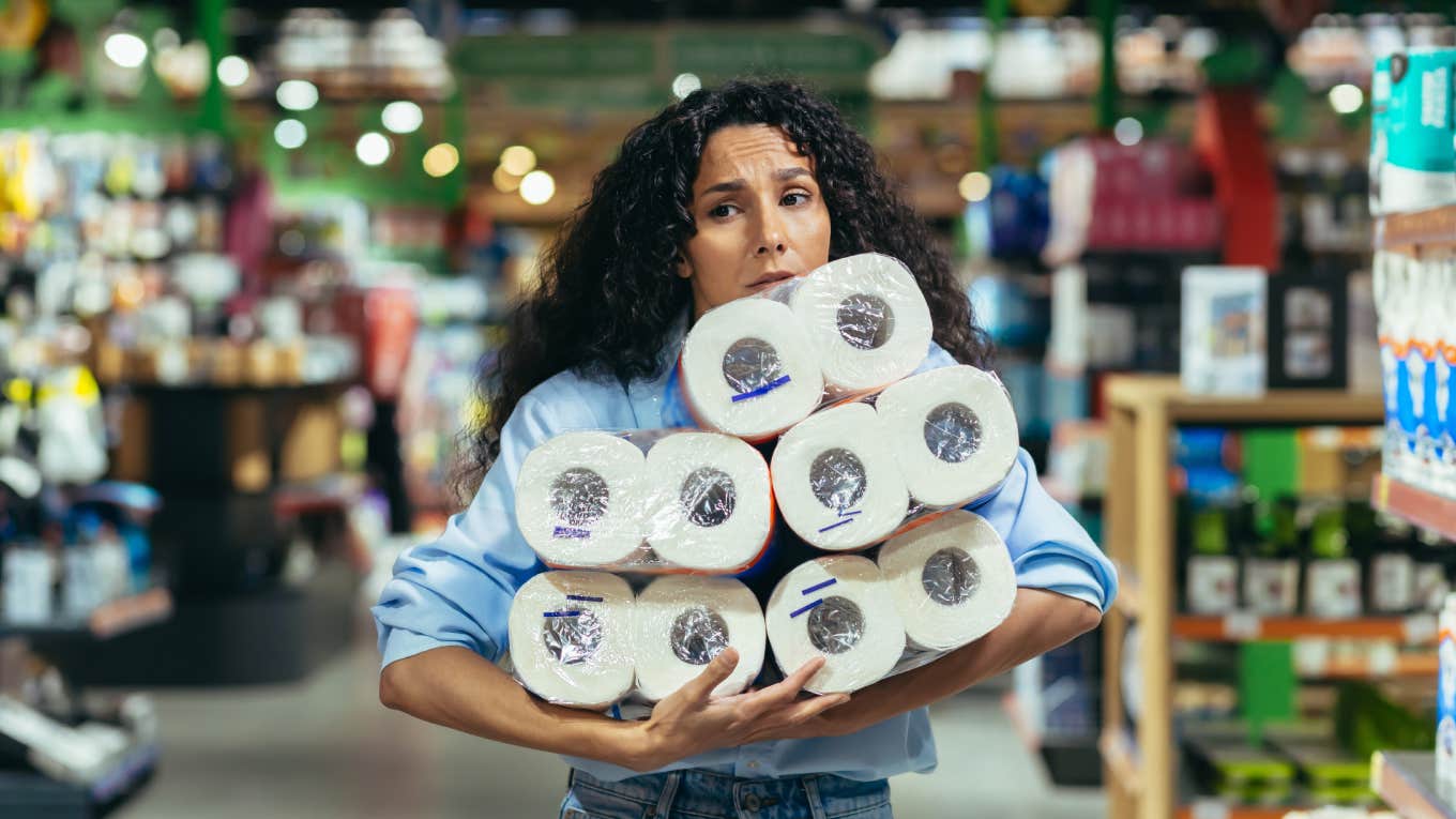 panicked woman holding toilet paper in supermarket