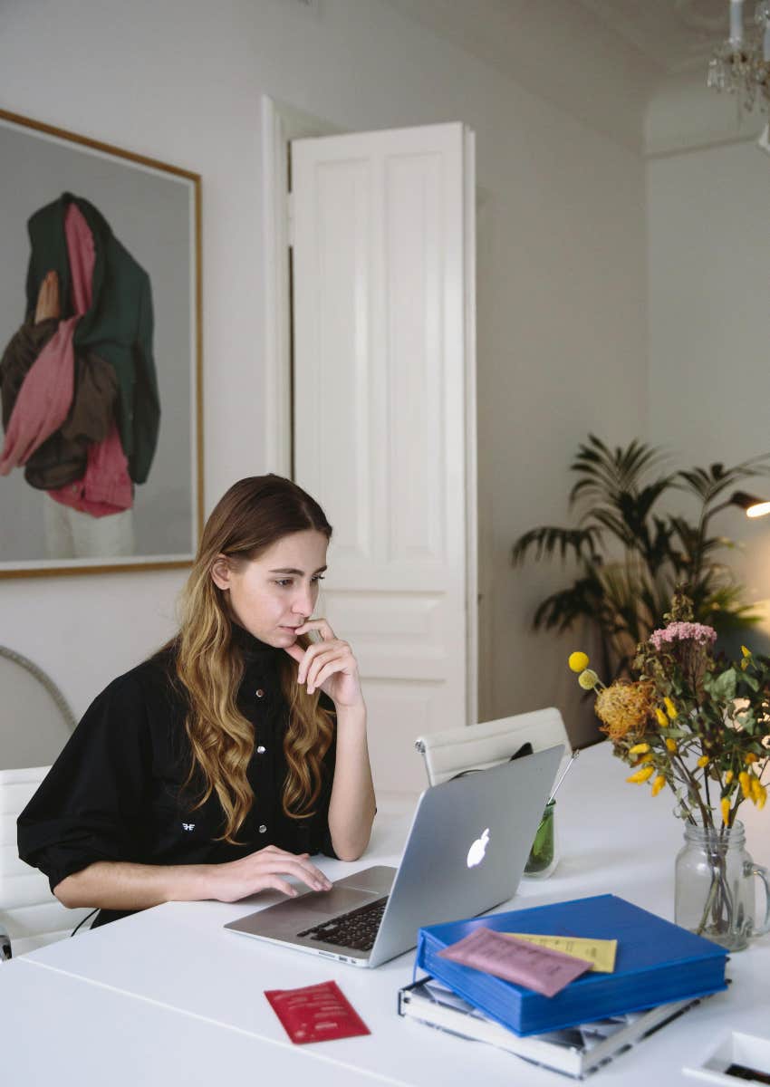 woman sitting at table working on her laptop