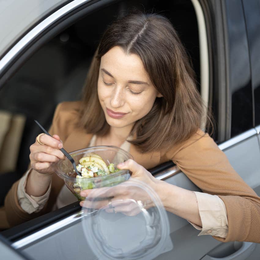 American worker eating by herself in her car during her lunch break