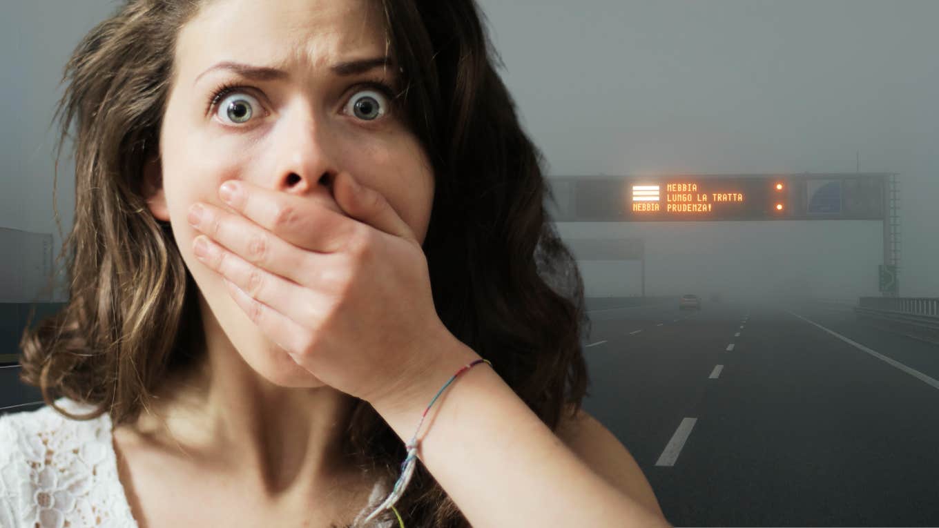 Fearful woman covering her mouth, driving on freeway.