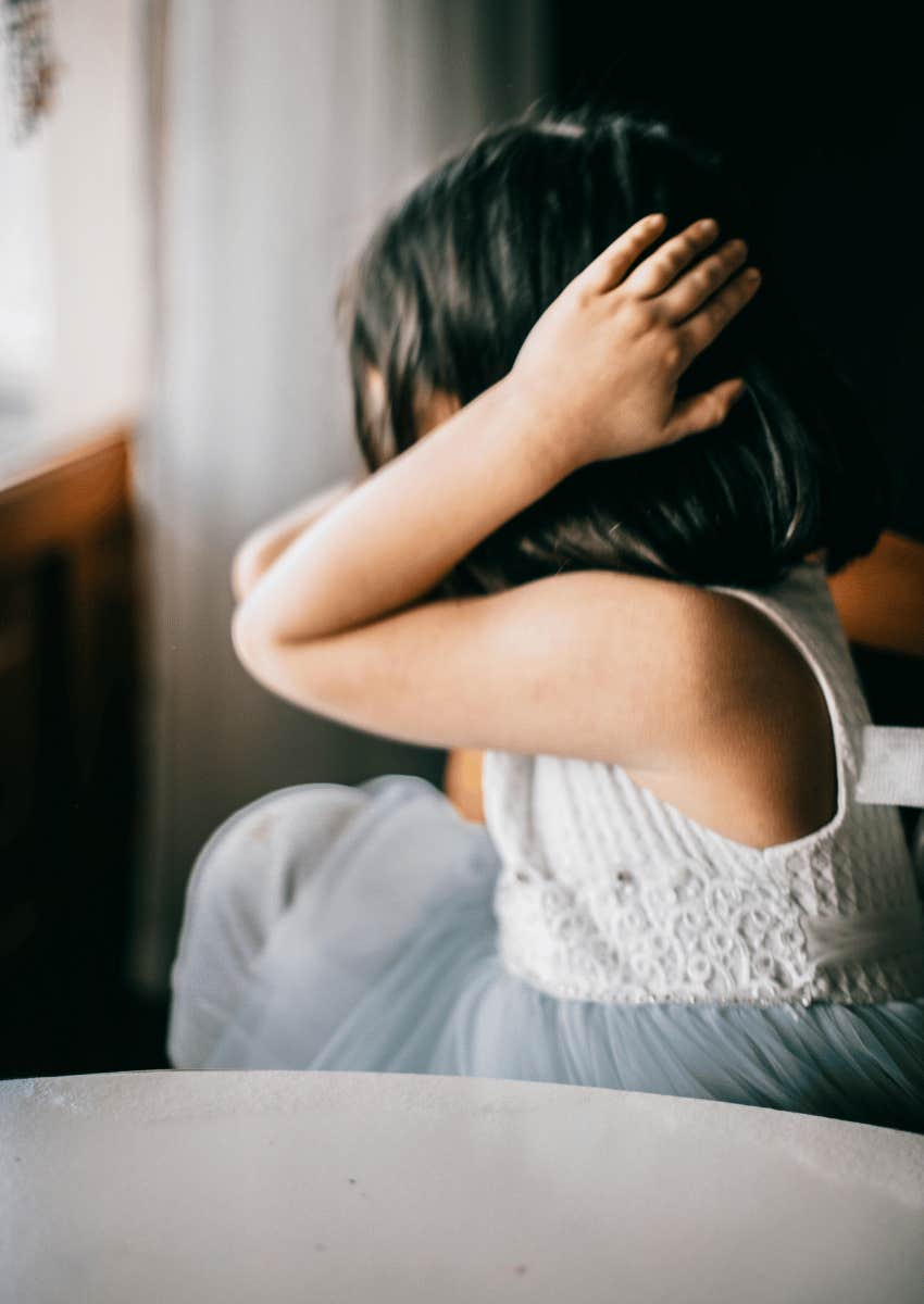 young girl covering her ears