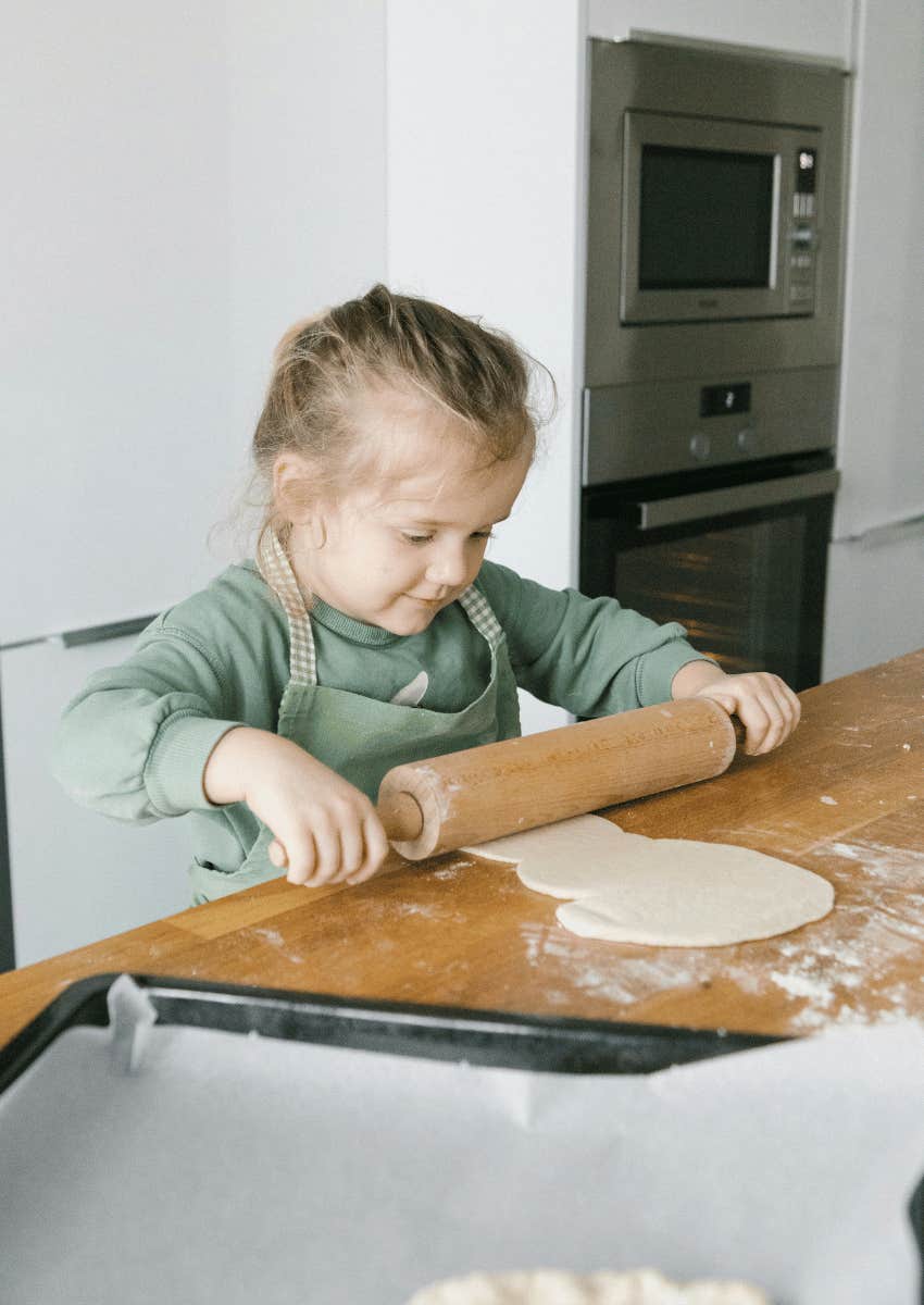 young girl rolling out dough