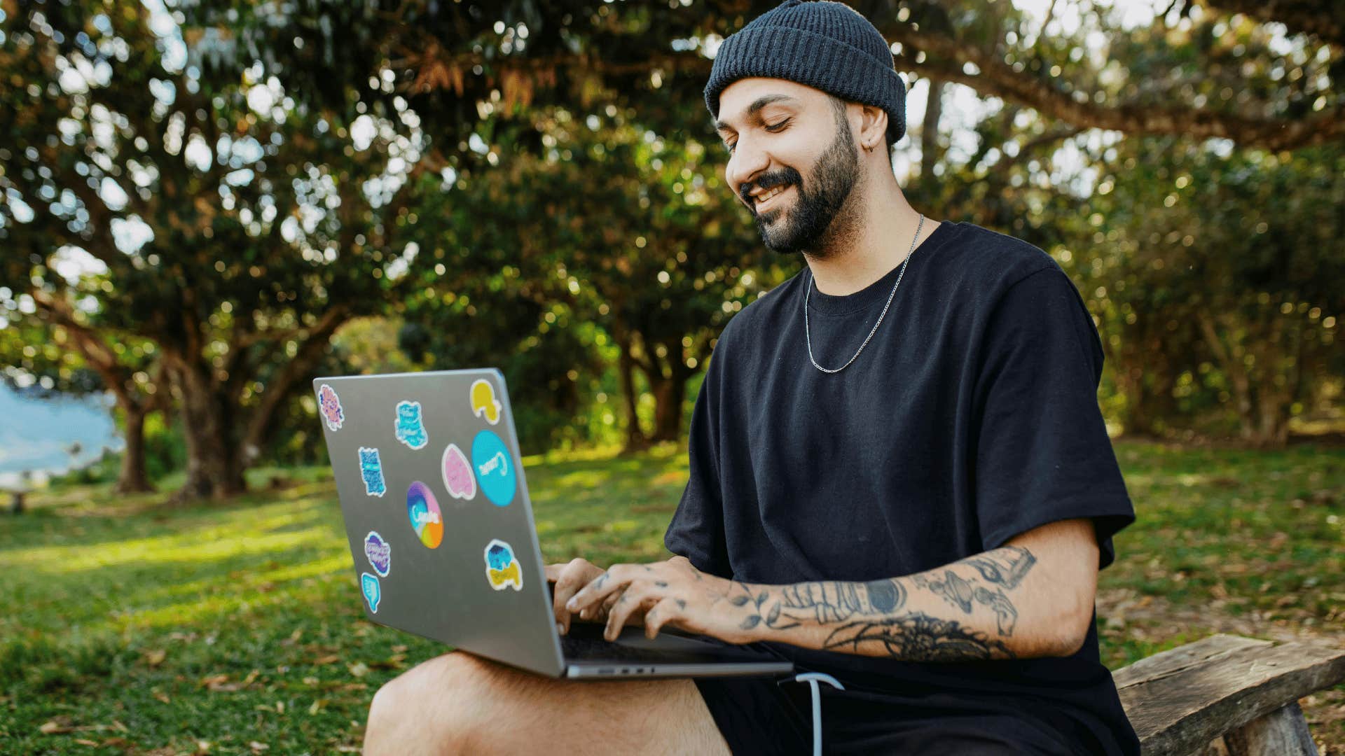 young man typing on a laptop outdoors