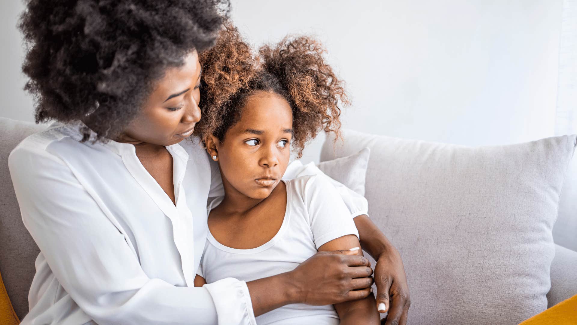 loving mother consoling an upset young girl