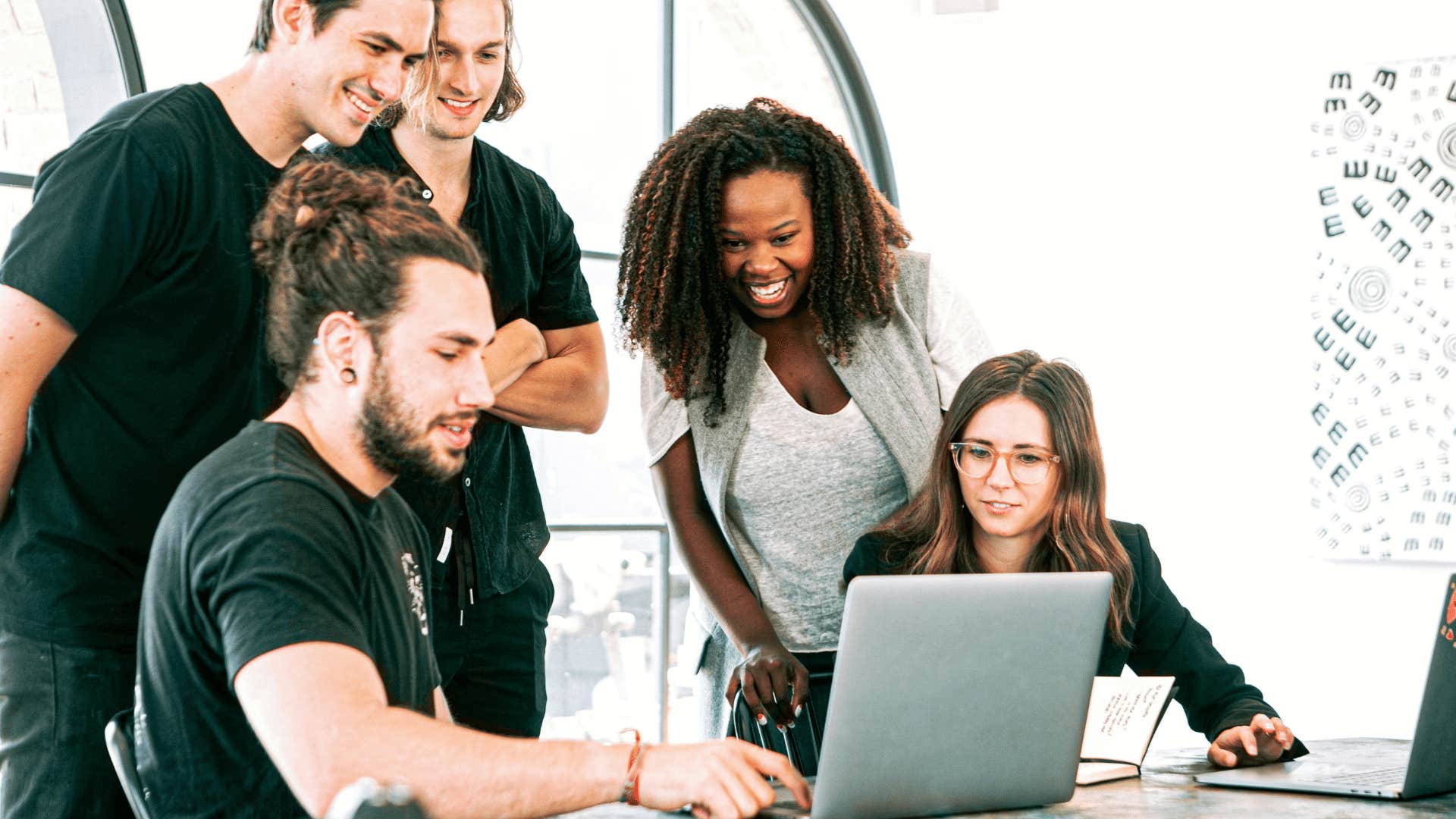 coworkers looking at an open laptop screen together