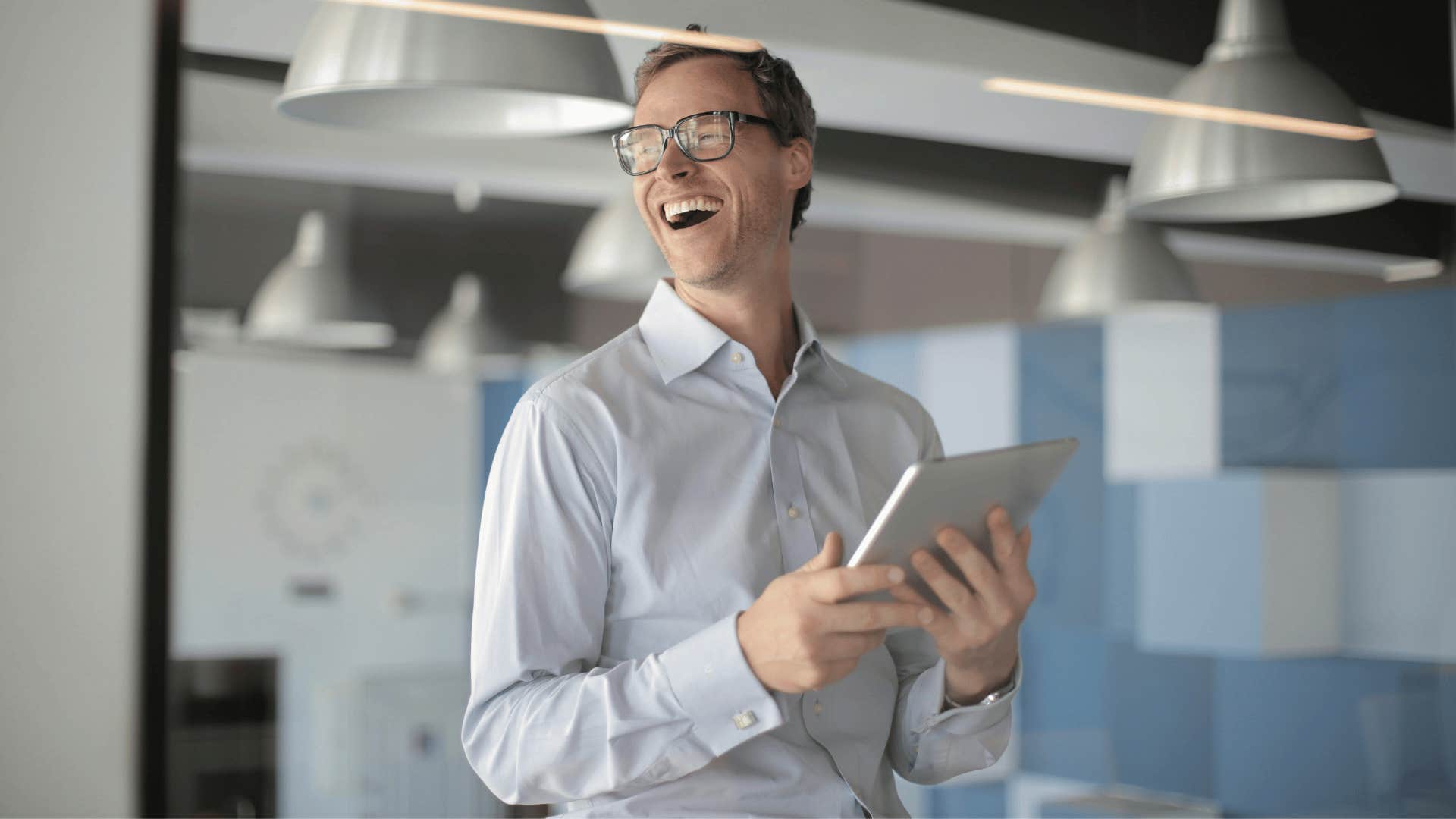 professional man holding a tablet and laughing