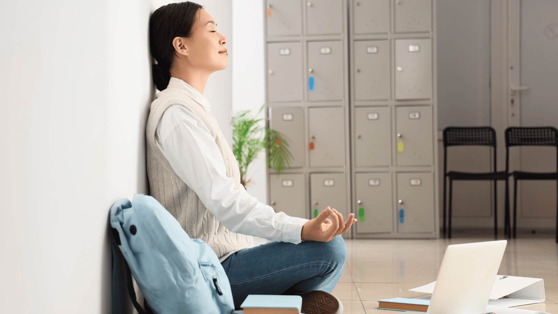 woman leaning against wall and meditating