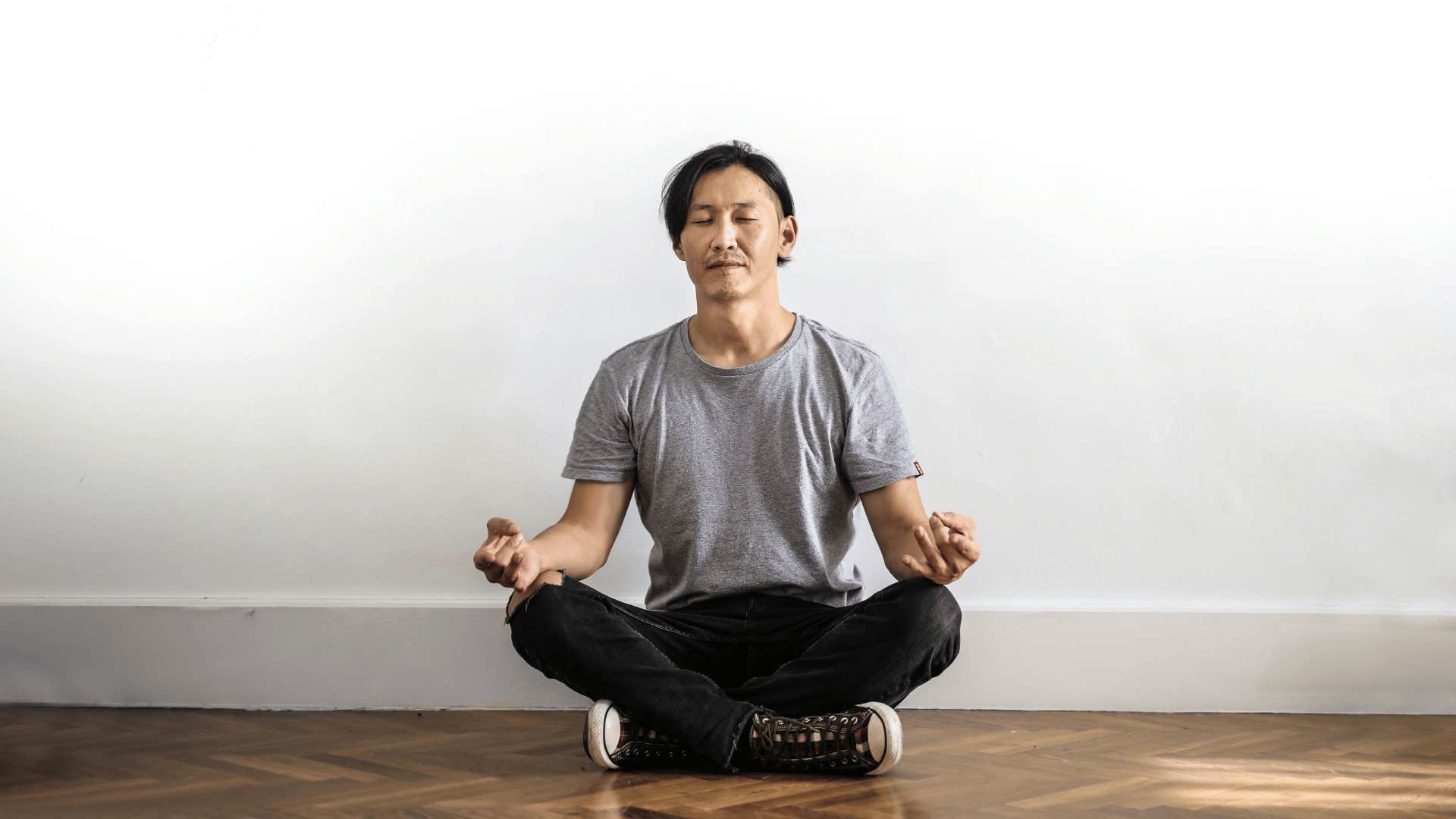 calm man sitting on the ground while meditating