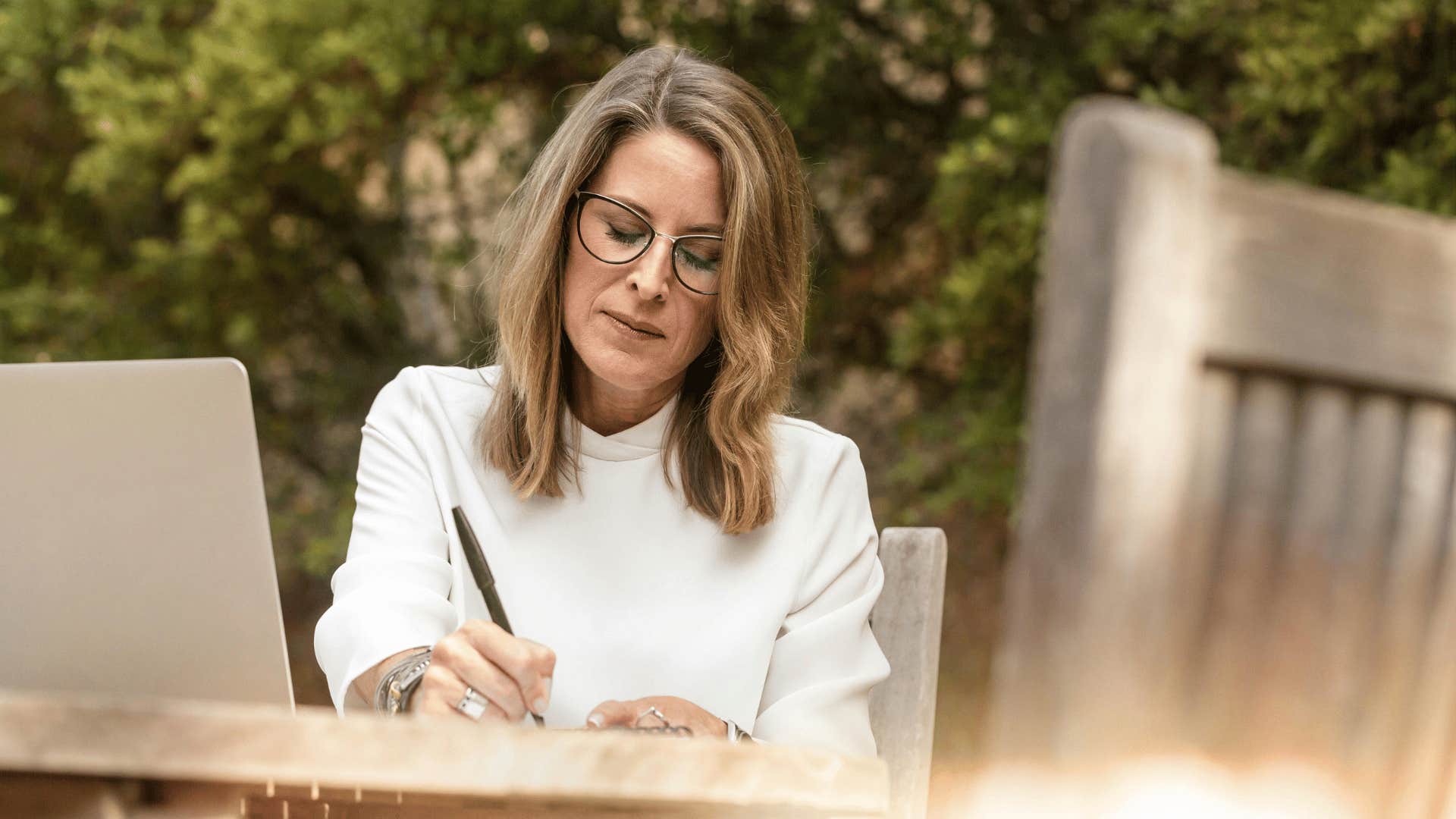 woman sitting outdoors and writing