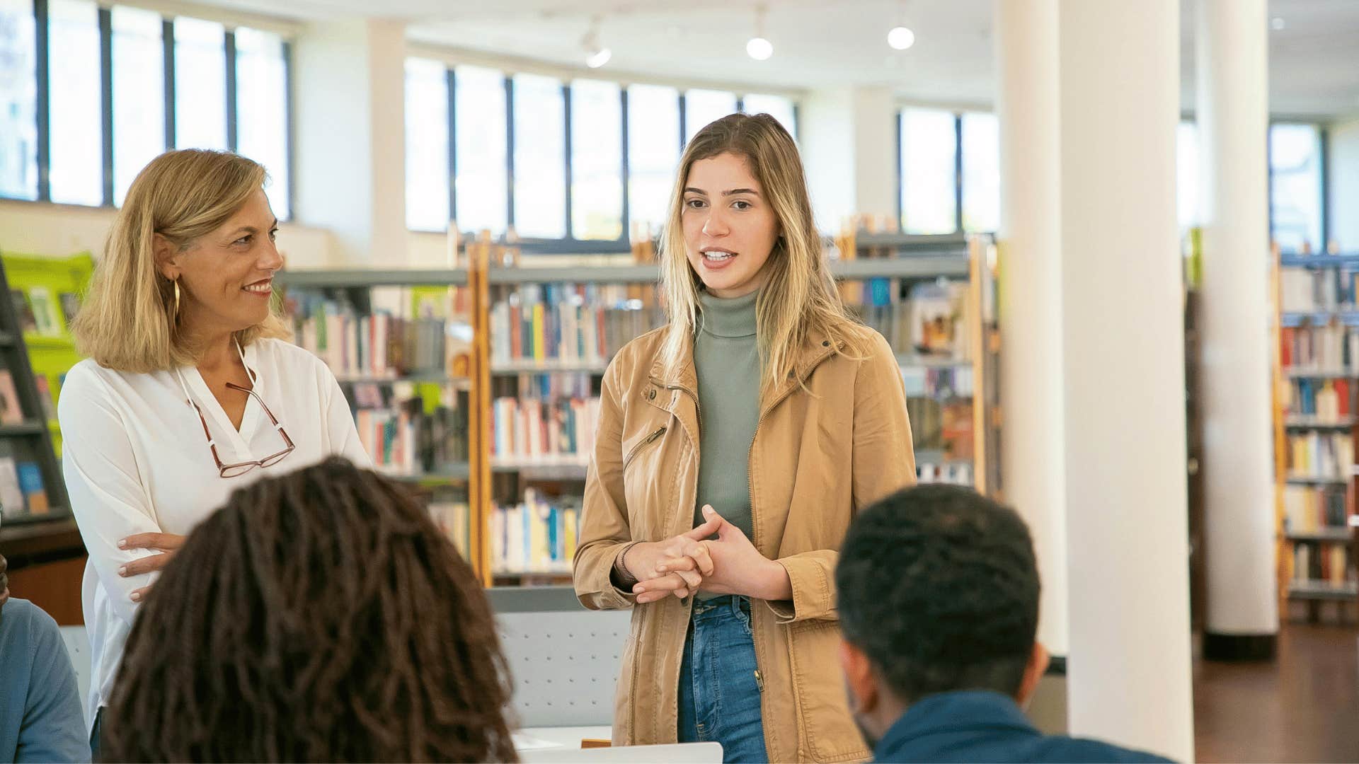 young woman speaking to a group of people in a library