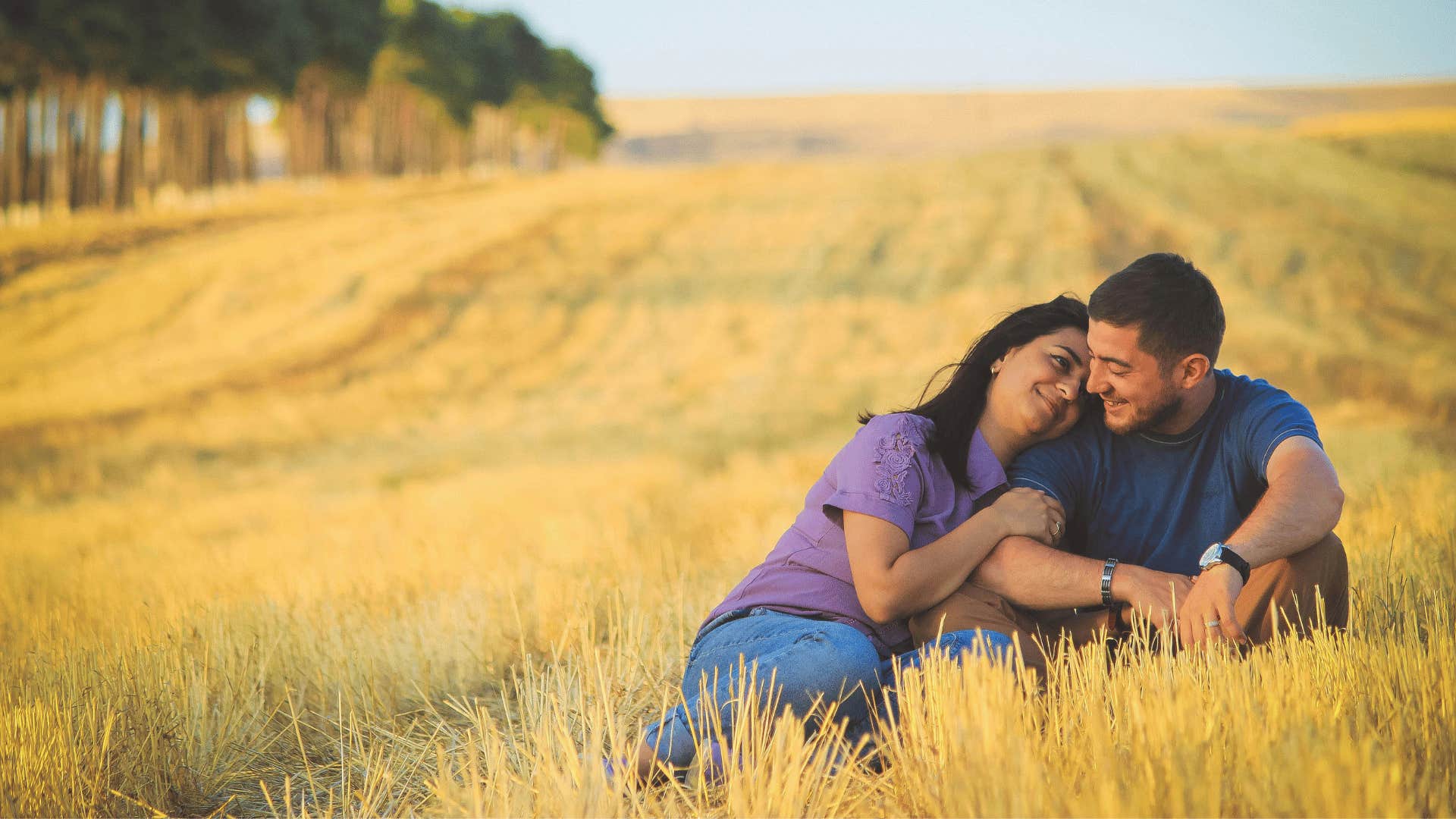 couple sitting in a grass field