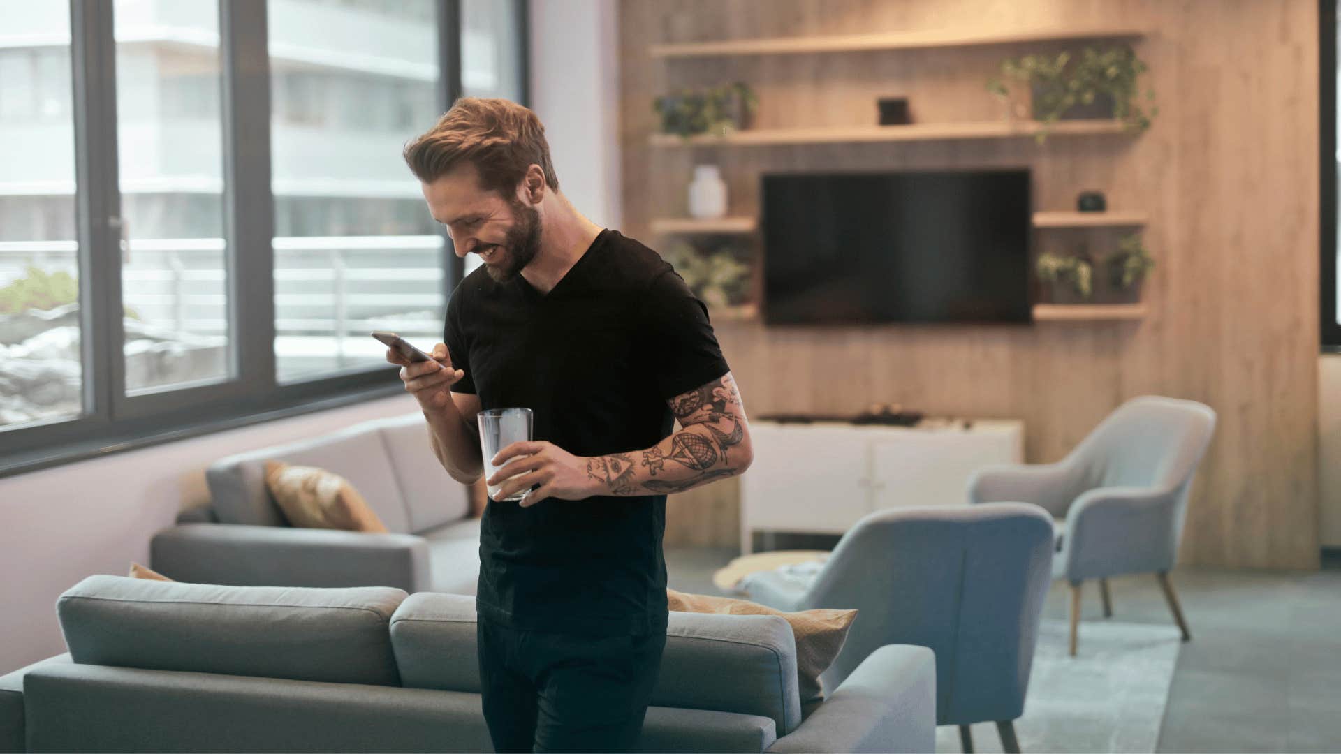 man smiling down at his phone