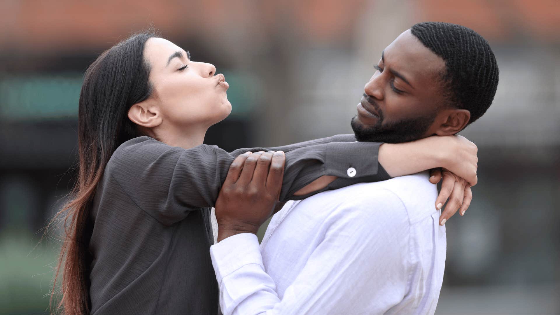 man trying to push woman away