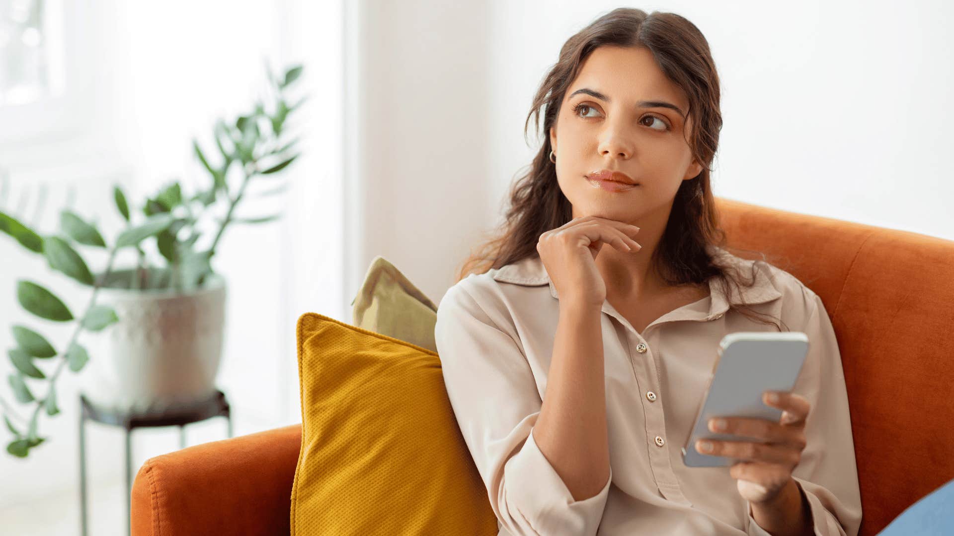 pensive young woman holding a phone