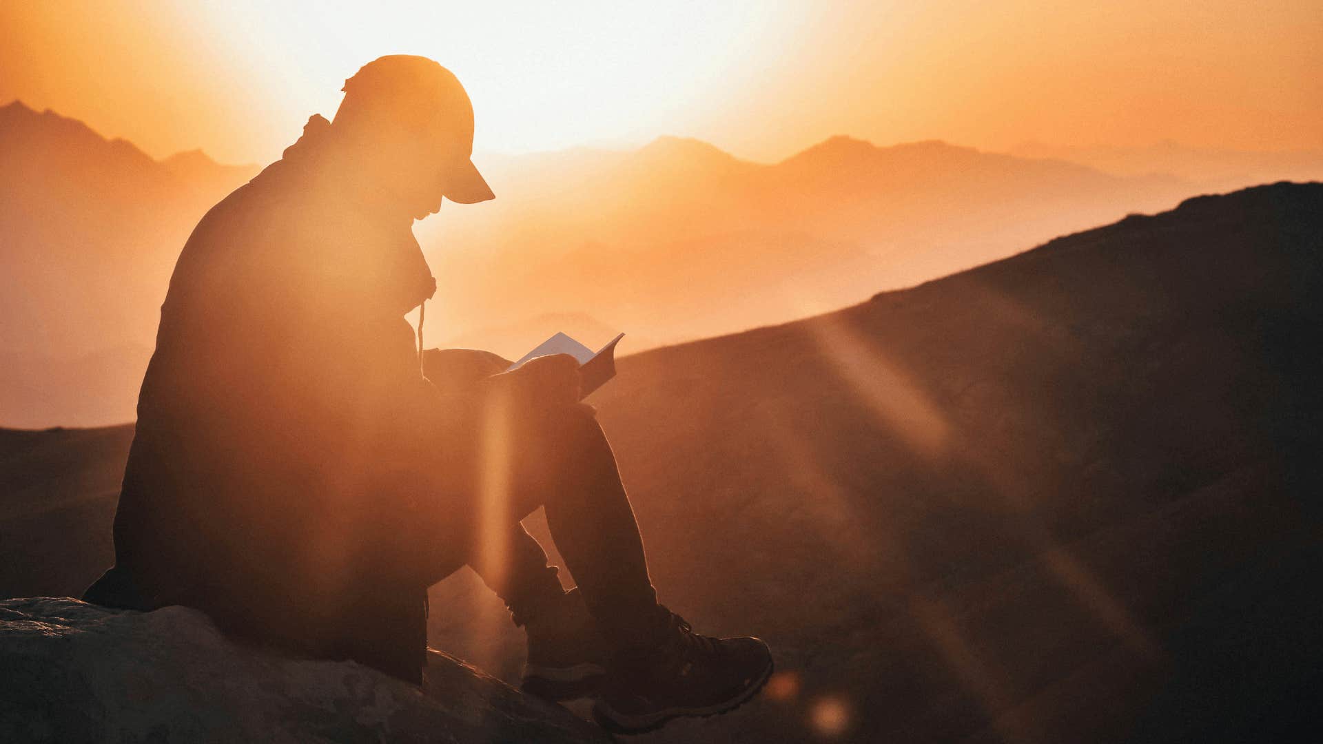 silhouette of man reading outdoors