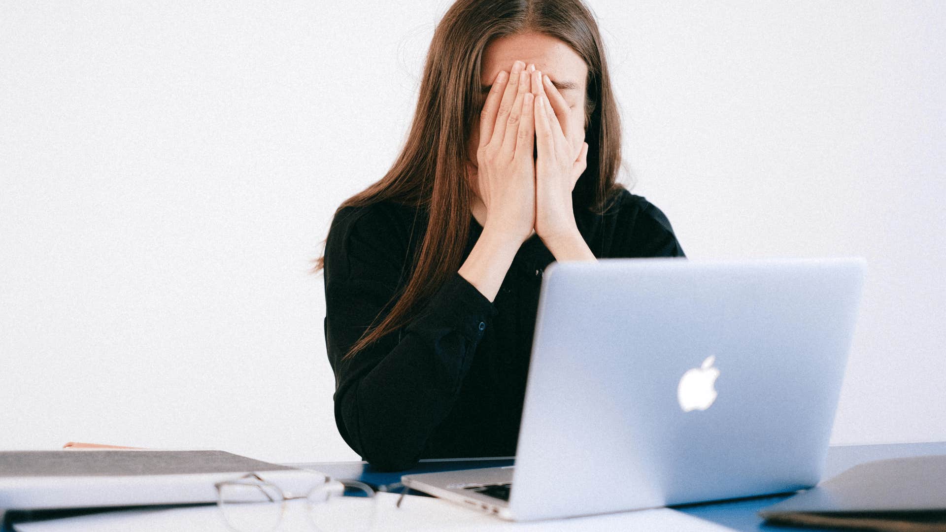 woman covering her face with her hands