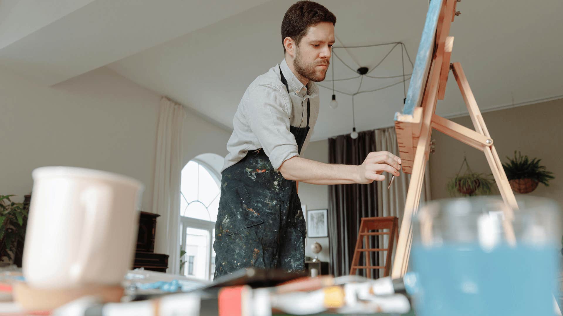 man wearing an apron while painting