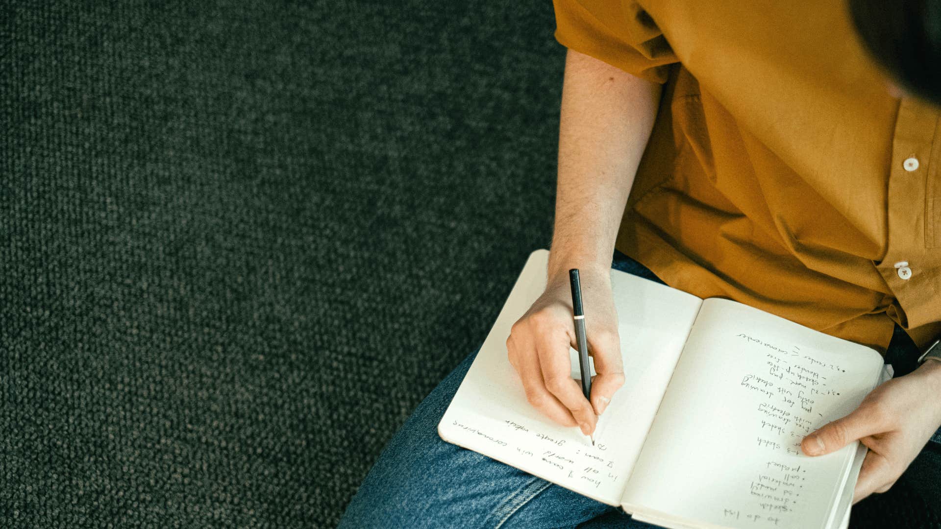 man writing a list in a notebook