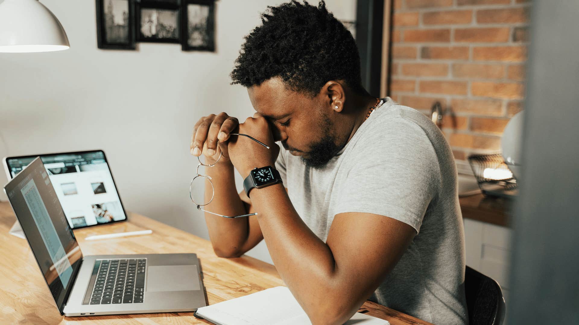 man holding his glasses while pinching the bridge of his nose