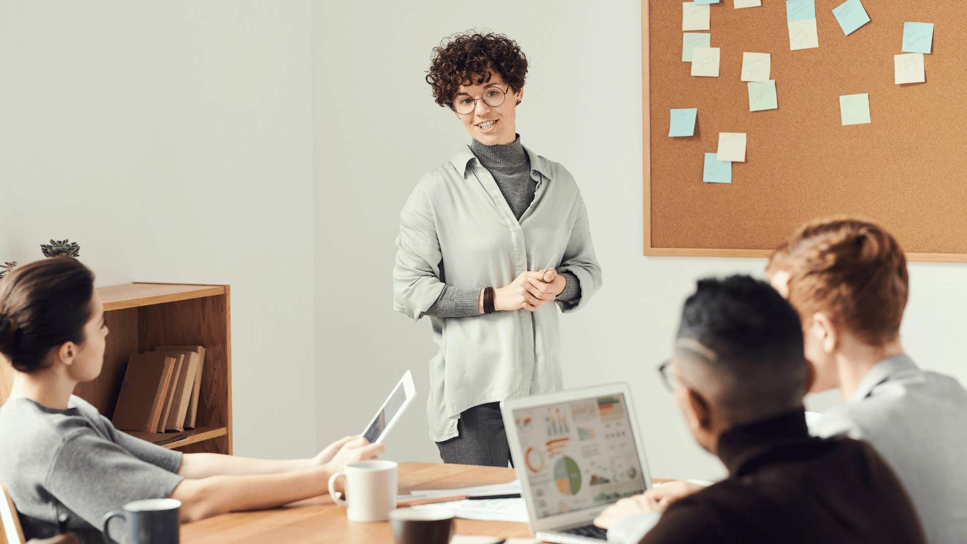 young woman presenting to group of coworkers