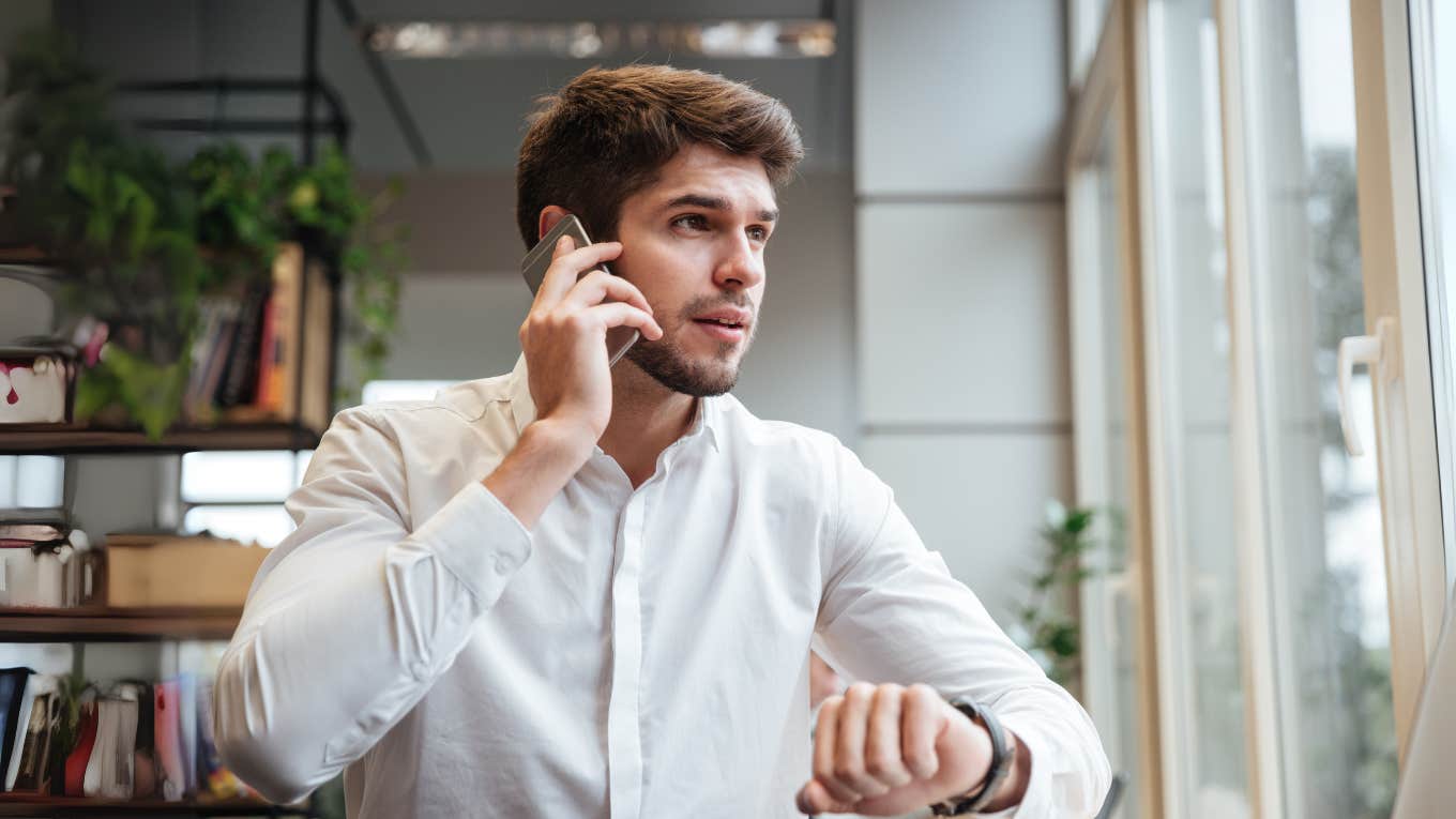 Man talking on phone and looking at watch