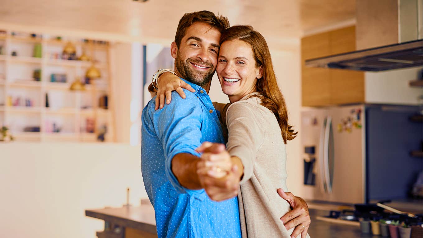 Man dancing with his partner in their kitchen.