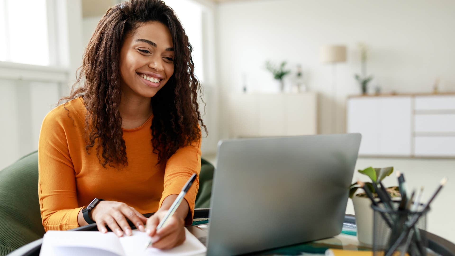 Woman smiling and typing on her laptop.