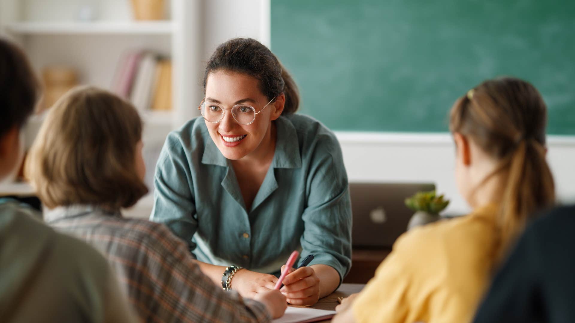 Teacher smiling at her students in a classroom.