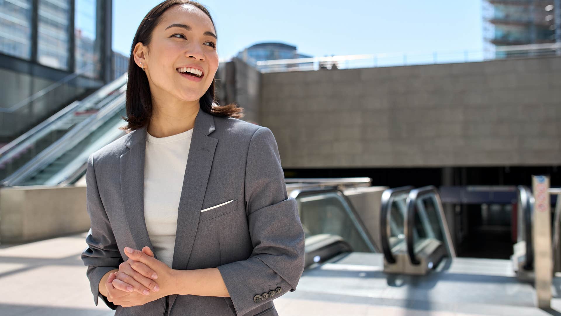 Professional woman smiling outside.