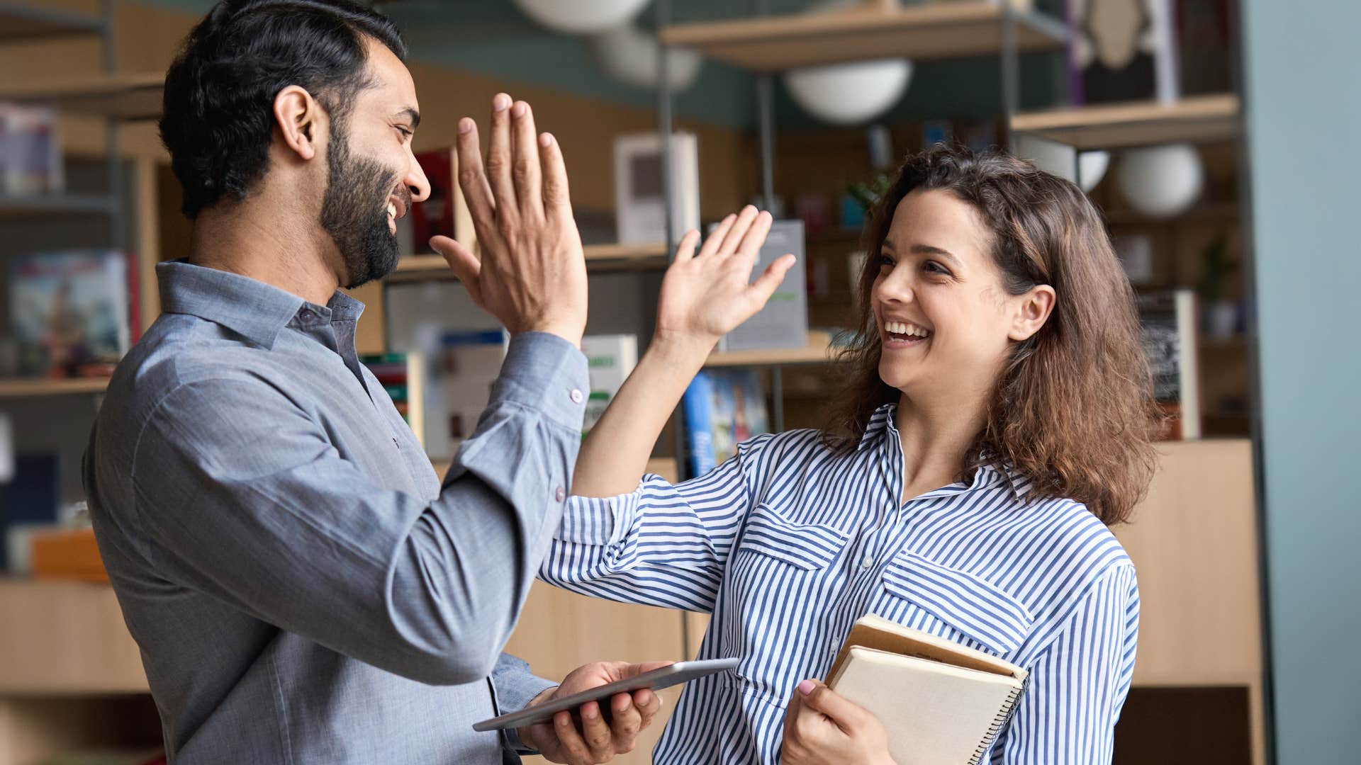 Two people high-fiving each other.