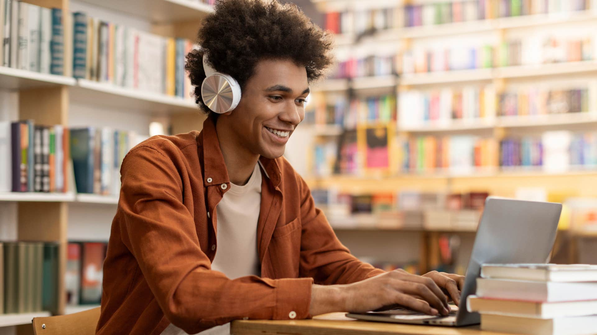 Man smiling and studying in a library. 