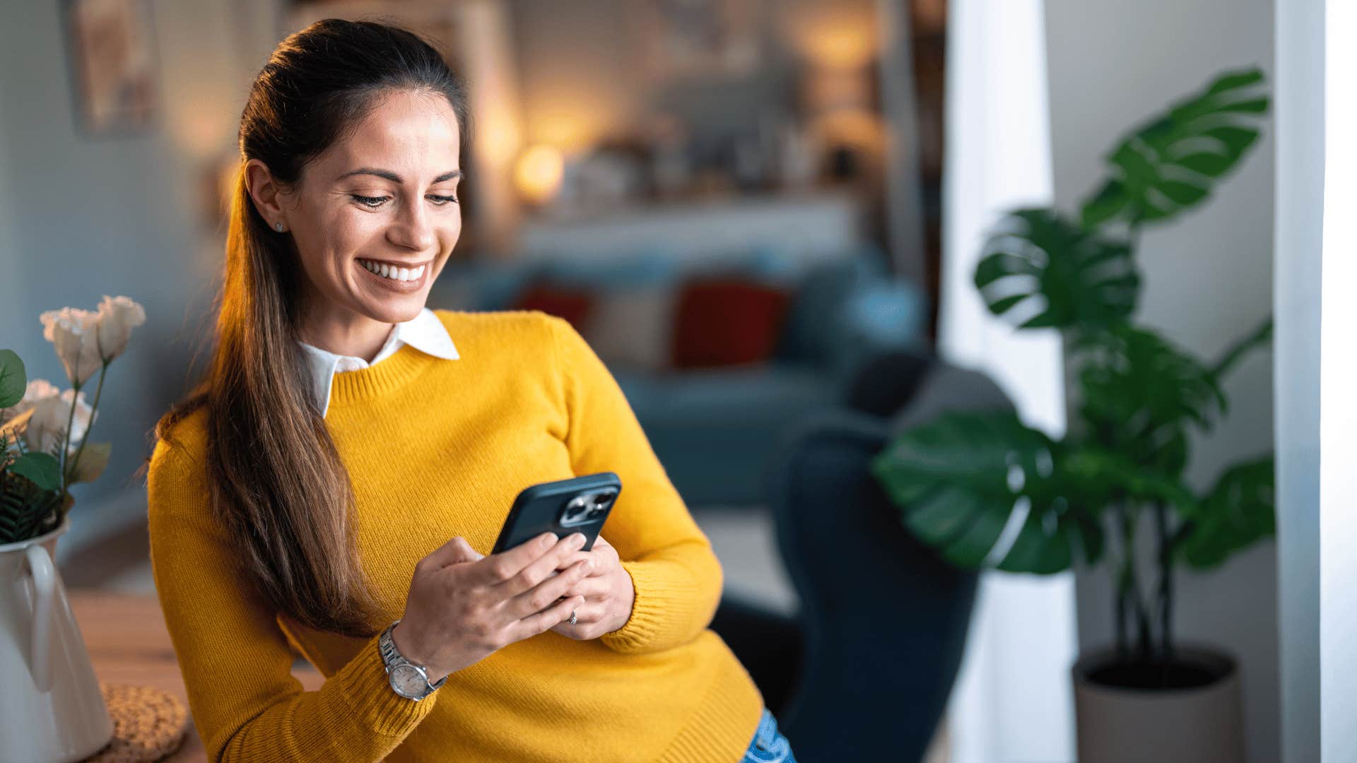 woman typing on her phone and smiling 