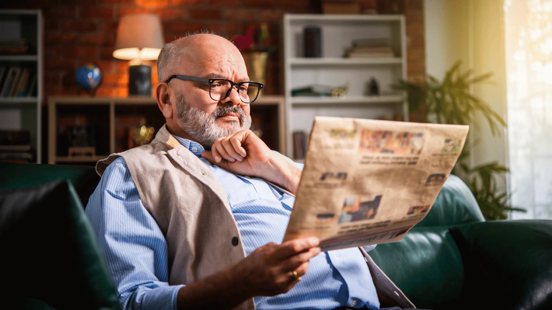 man reading newspaper while sitting down