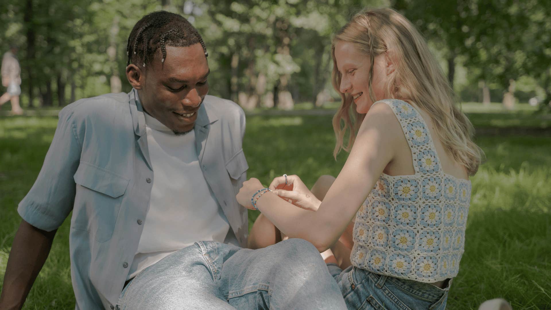 woman putting bracelet on man's arm