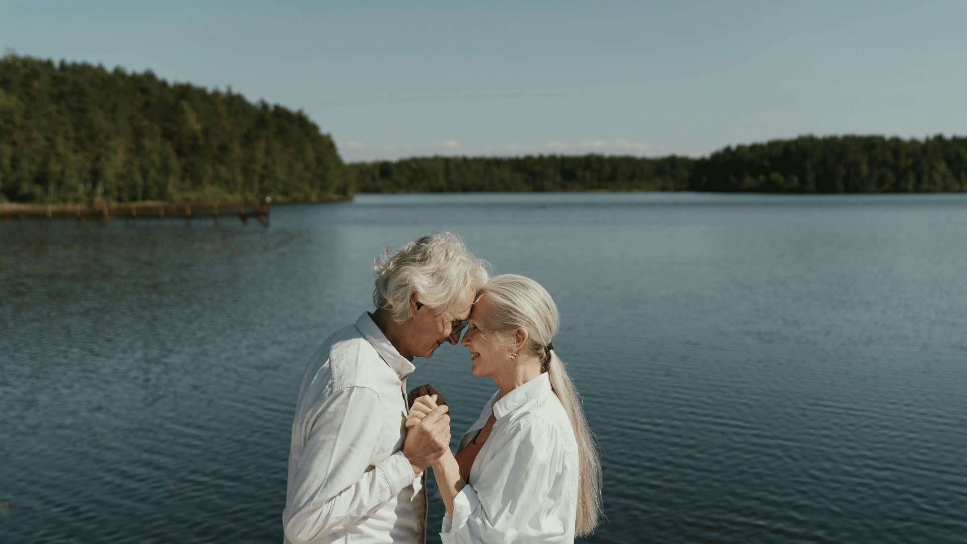 older couple embracing by the water