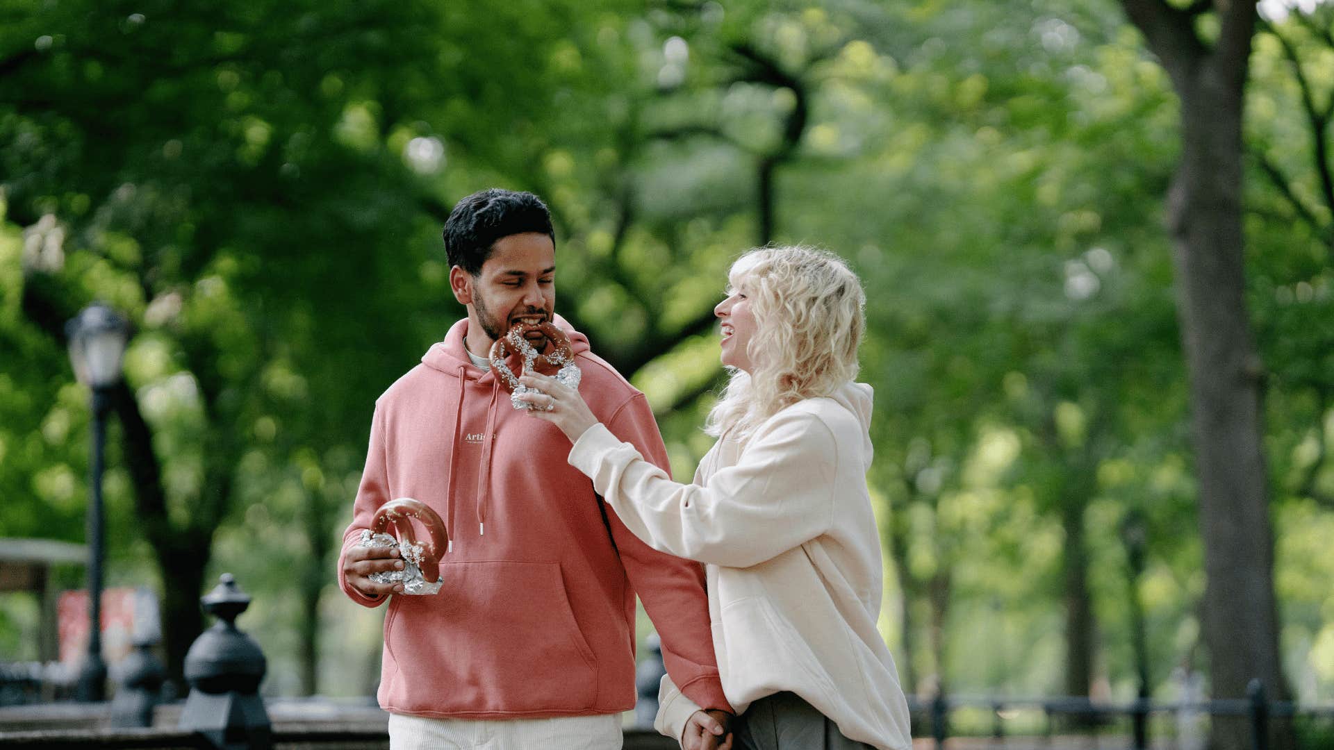 couple on a date in a park eating pretzels