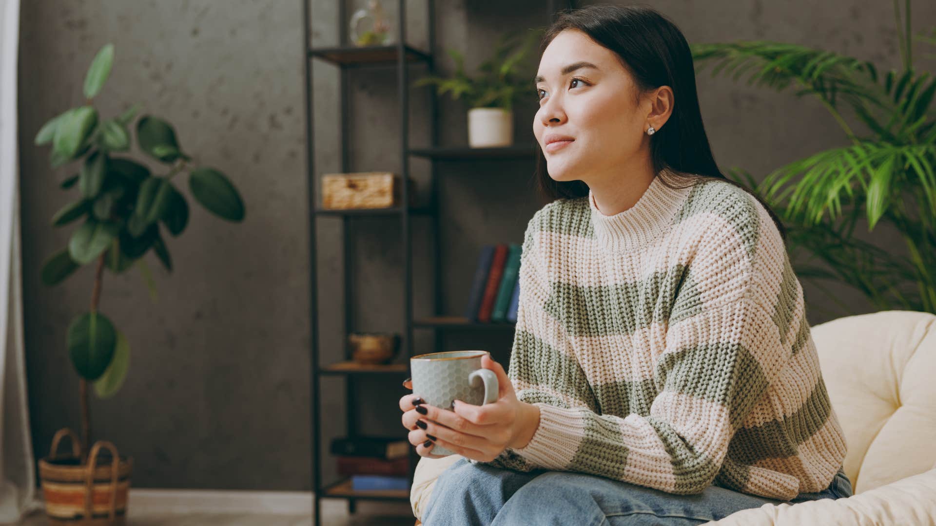 Woman smiling and holding a coffee mug. 