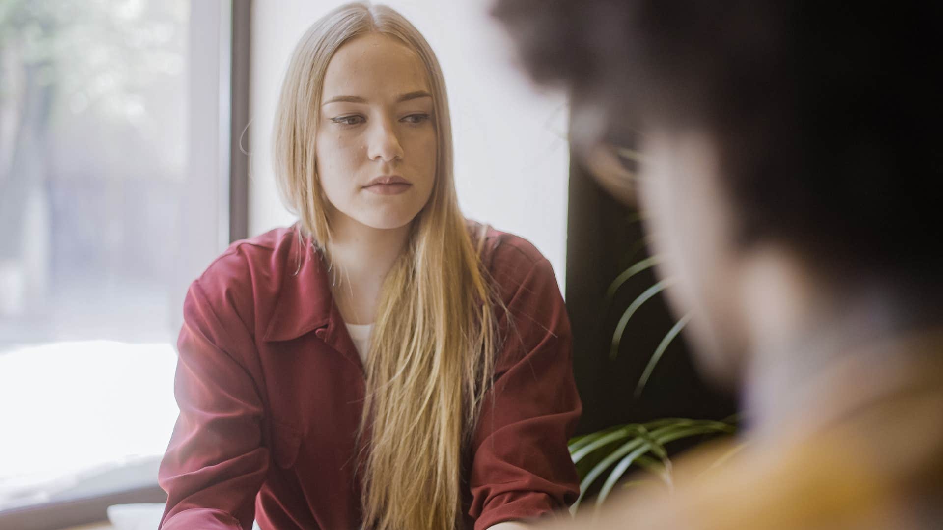 Woman looking annoyed while talking to a man.