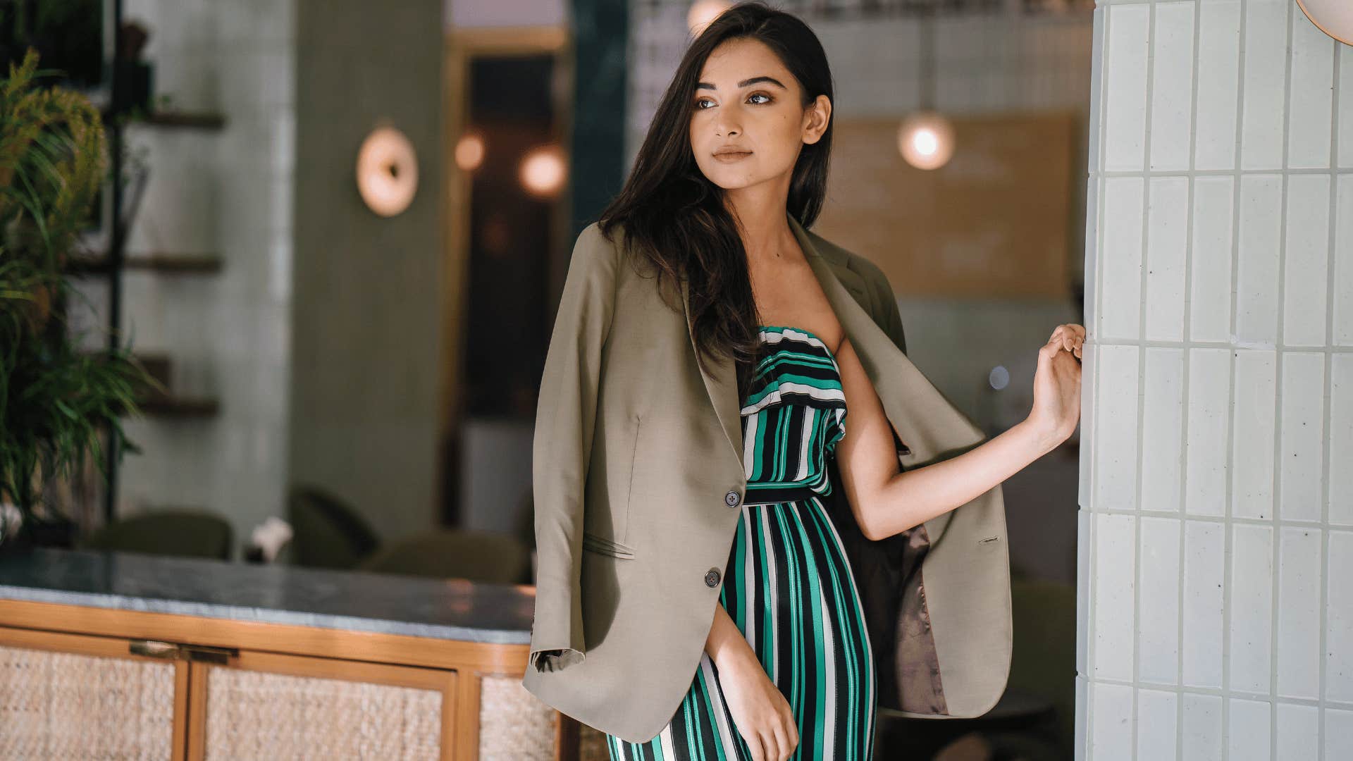 woman looking poised while leaning against wall