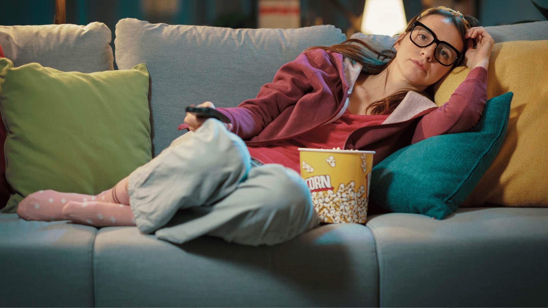 woman eating popcorn and laying down