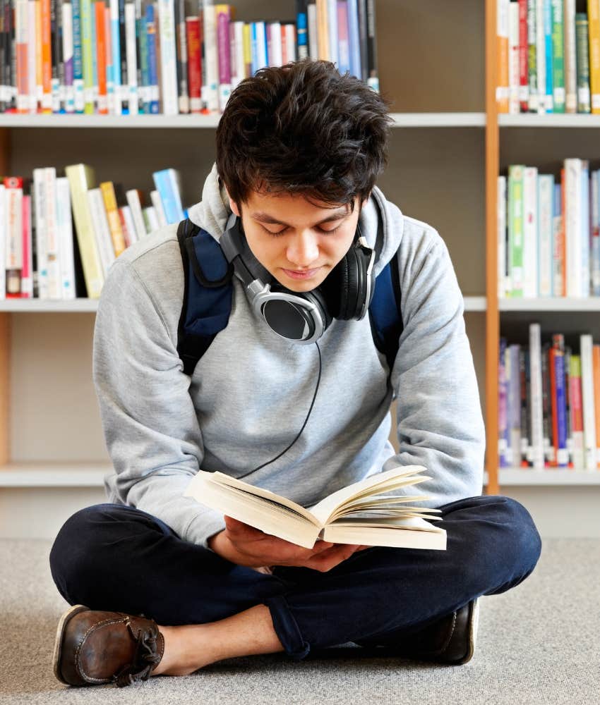 college student reading a book in the library