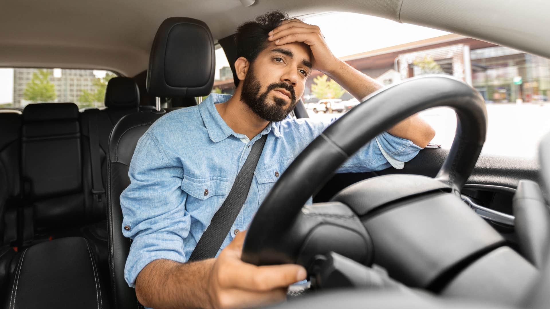 Man looking stressed while driving a car