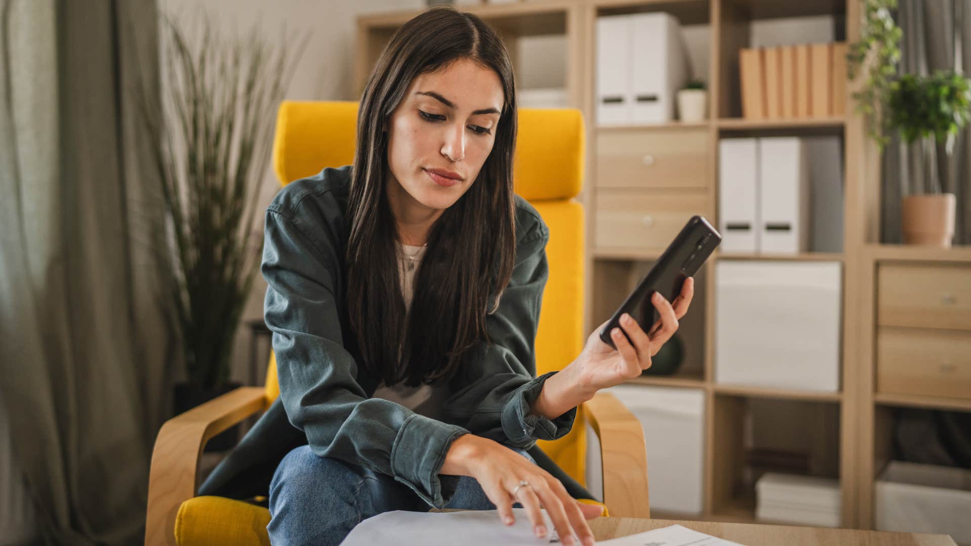 Young woman looking upset doing her bills