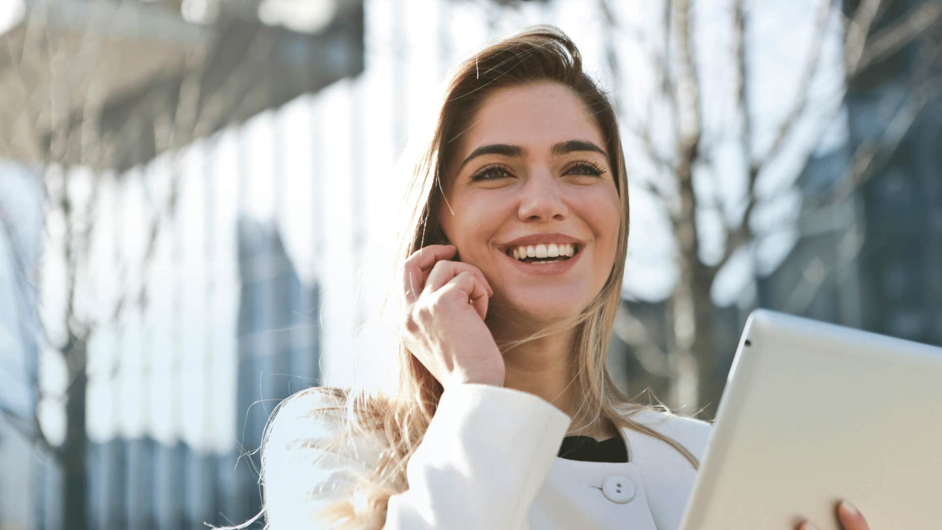 woman holding a tablet and smiling