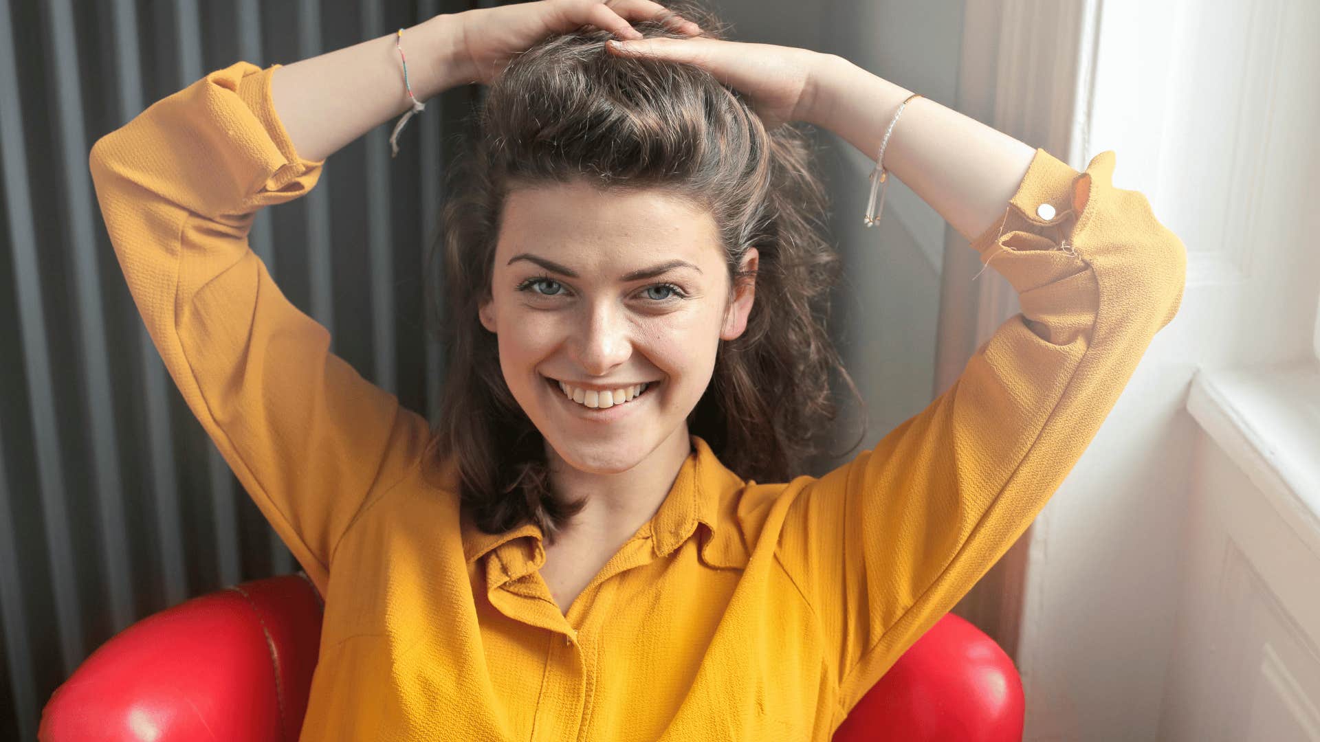 woman holding her hair above her head and smiling