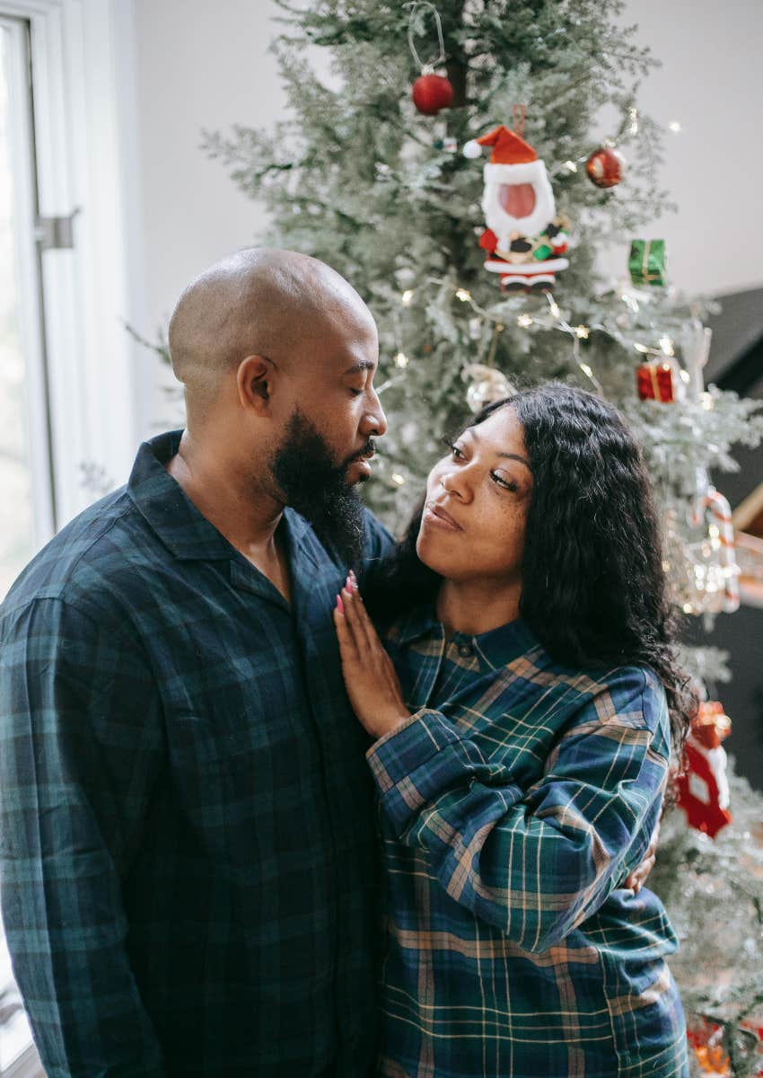 couple standing in front of Christmas tree