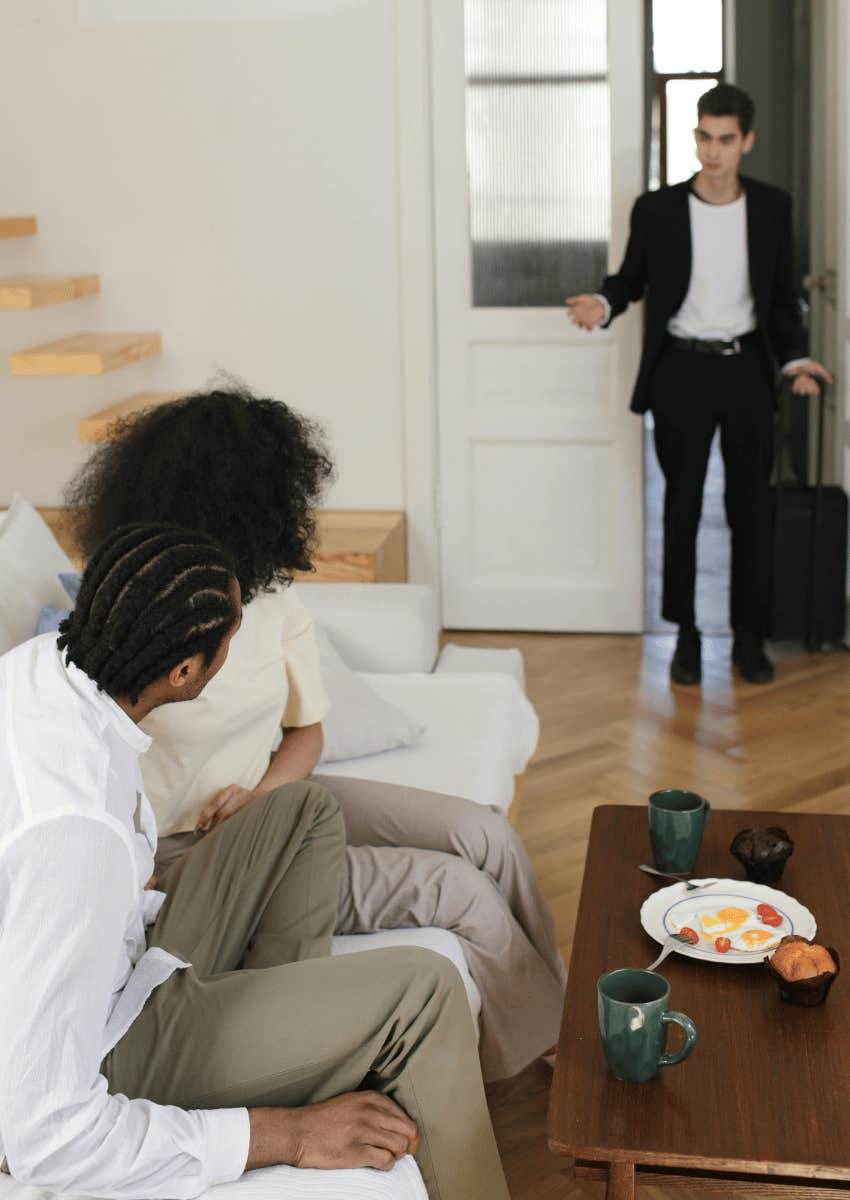 couple staring at shocked man in doorway