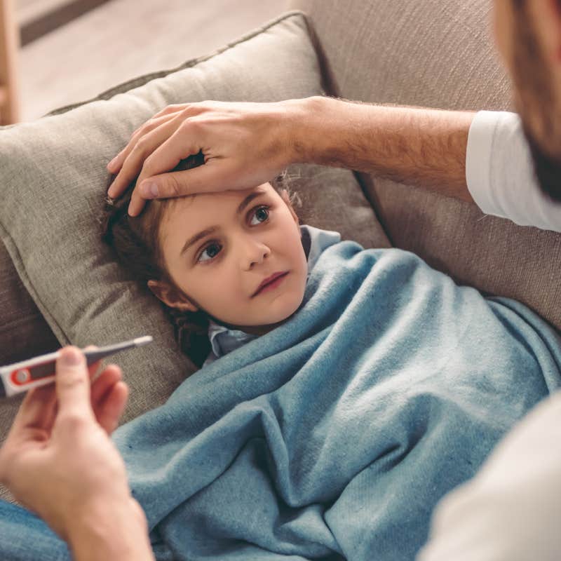 close up shot of dad checking son's temperature